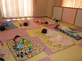乳児室 - 全園舎冷暖房完備、更に全保育室、乳児室は健康的な電気による床暖房で、足もとを暖めます。